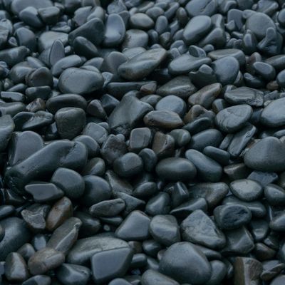 A perfectly balanced stack of smooth stones on a dark background.